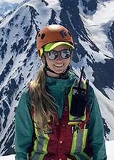 Kim standing on a mountain summit